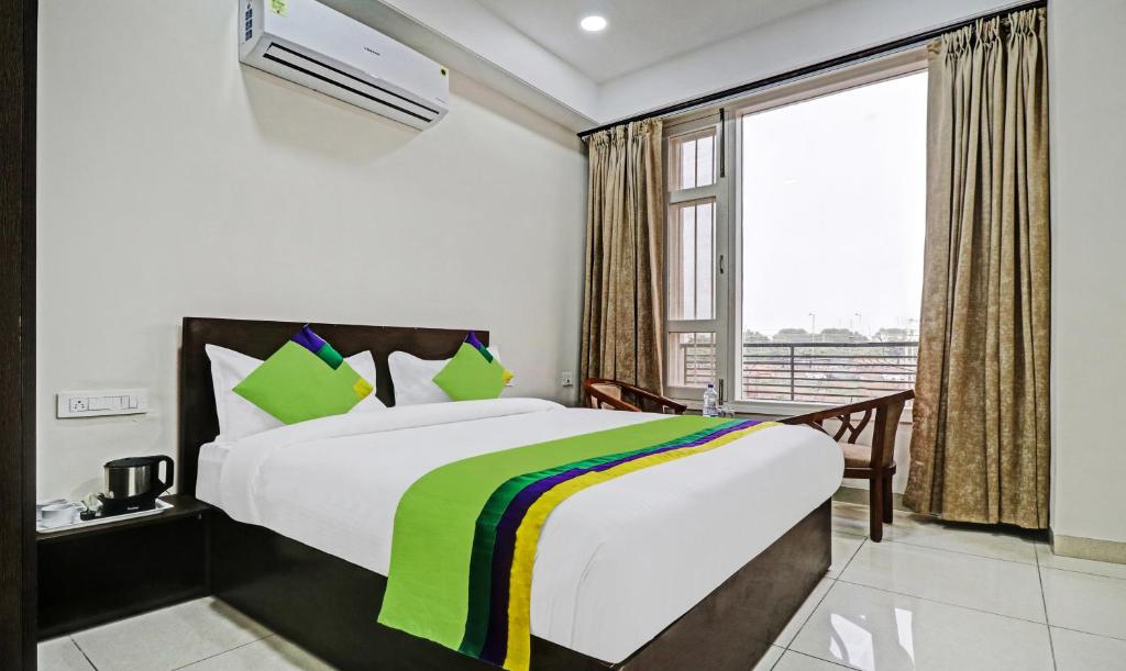 a bedroom with a bed and a large window at Treebo Trend Kamron Regency Sector 80 in Mohali