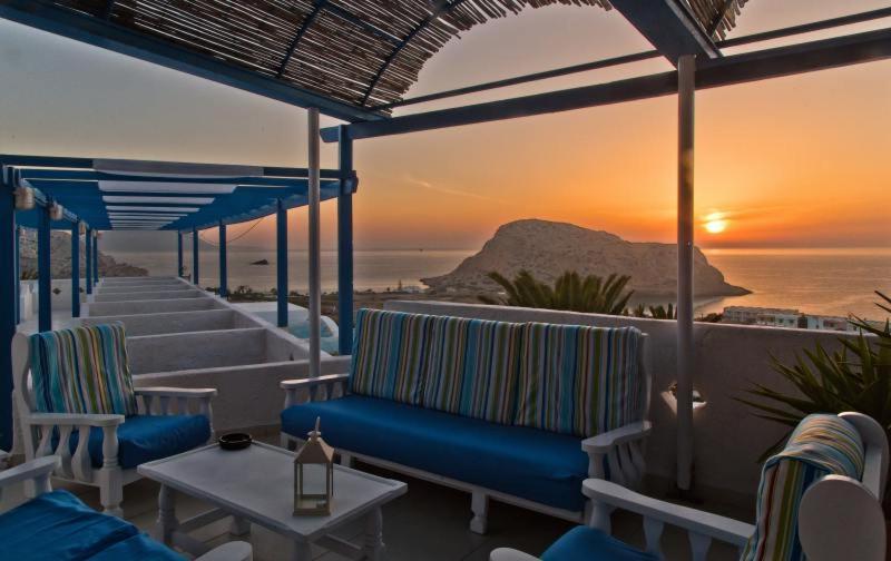 een patio met stoelen en uitzicht op de oceaan bij Bluu Bahari Hotel in Karpathos