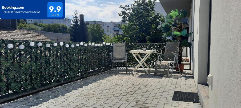 a fence with a table and chair in a yard at Baman Apartment in Cluj-Napoca
