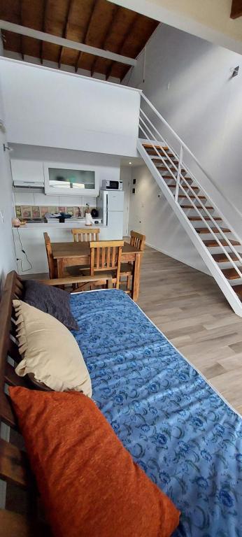 a bedroom with a bed and a staircase at Aparahik in Ushuaia