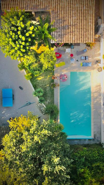 - une vue sur la piscine bordée d'arbres et de fleurs dans l'établissement Les Hauts de Chaudeyrac, à Bagnols-sur-Cèze