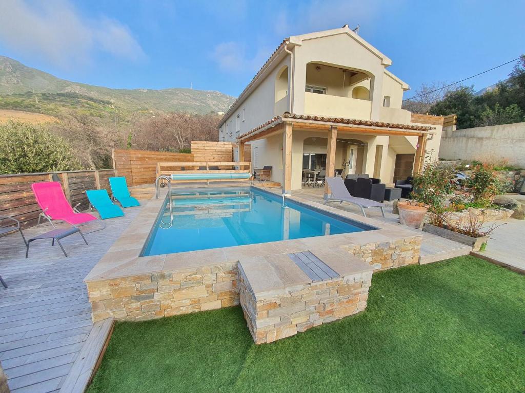 a backyard with a swimming pool and a house at Appartement Piovanacce - T3 avec pisicne privée 10min de Saint-Florent in Barbaggio