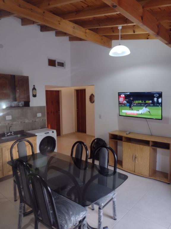 a dining room with a table and a tv at casa particular adrogue entrada individual in José Mármol