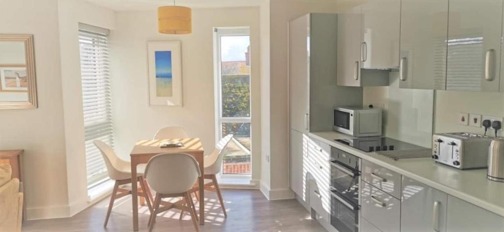 Apartment 9 Estuary Reach في اكسماوث: مطبخ مع طاولة وكراسي في مطبخ