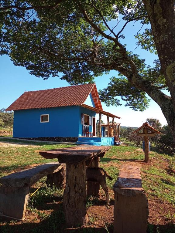 uma casa azul com um banco à frente em Chalé Santa Rita de Cassia em São Tomé das Letras