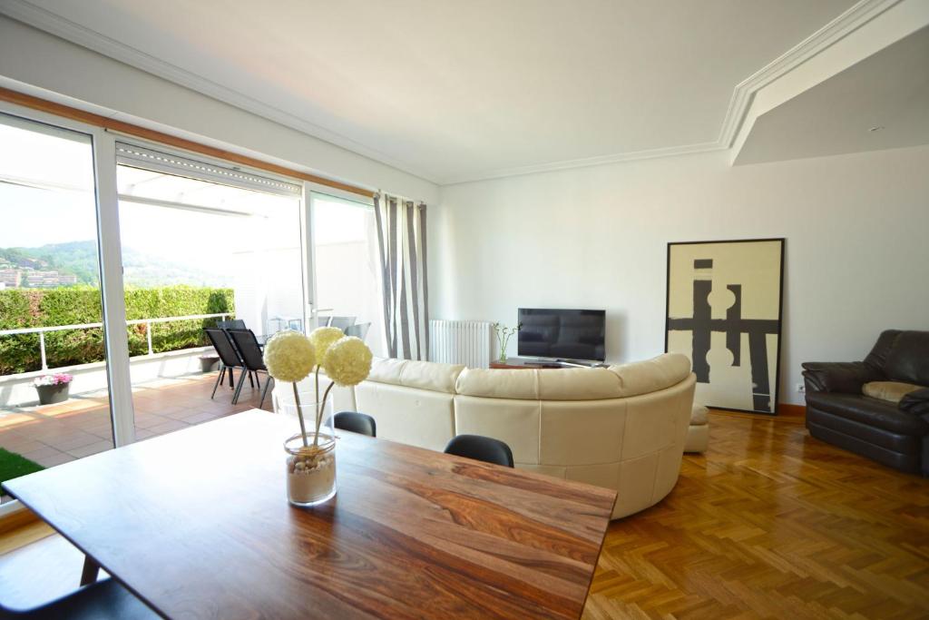 ein Wohnzimmer mit einem Sofa und einem Tisch in der Unterkunft Go Donosti Villa Berio in San Sebastián