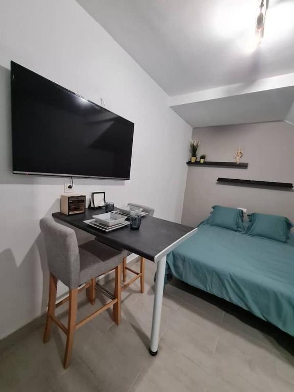 a bedroom with a desk with a bed and a tv at CASCAIS BEACH in Puerto del Rosario