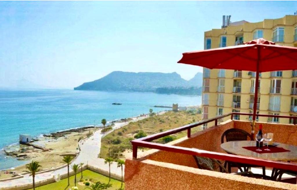 balcón del hotel con sombrilla y vistas al océano en Cinema Duplex en Calpe