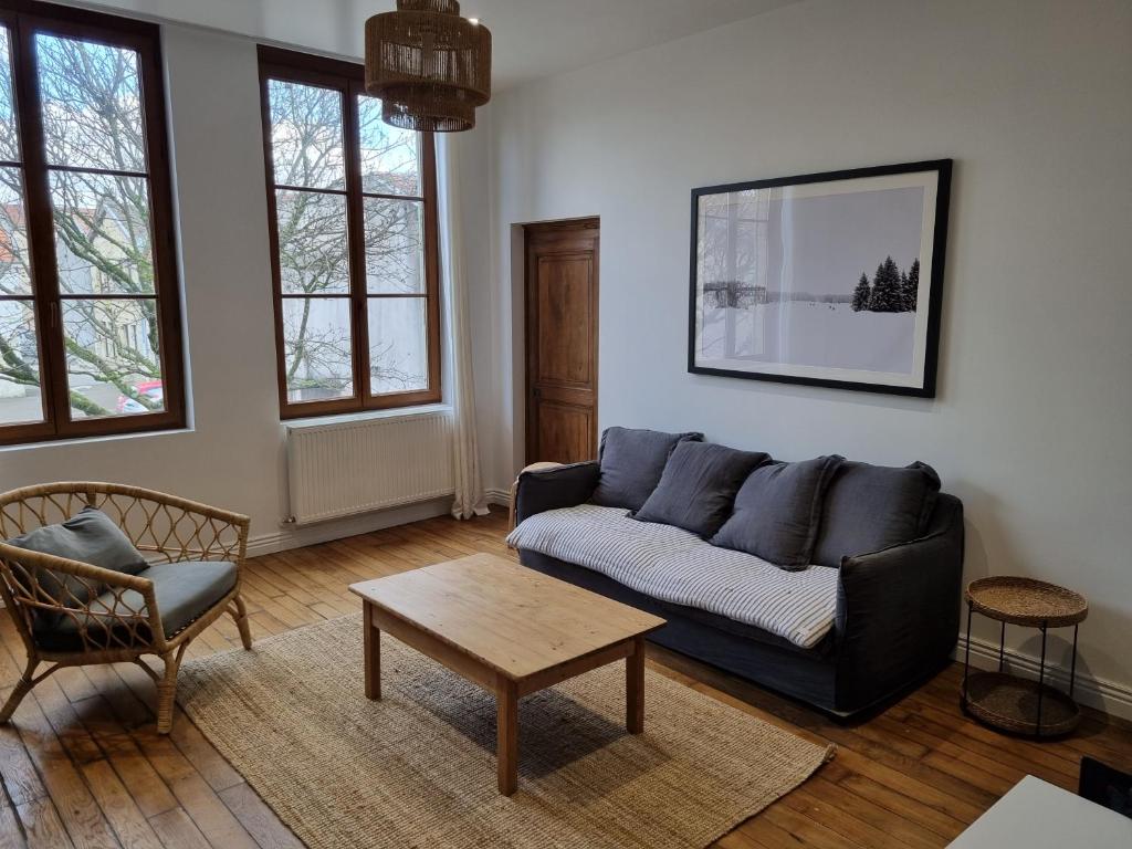 a living room with a couch and a table at Catel Duplex coeur de ville de Saint Dizier 2 chambres in Saint-Dizier