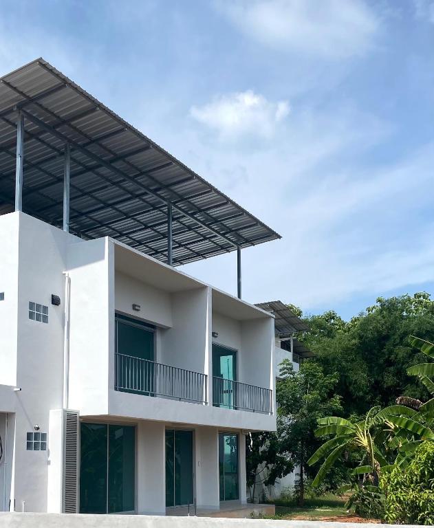 a white house with a balcony at baan thammada in Nan