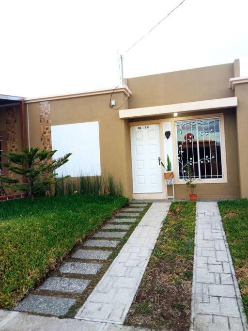 a house with a walkway in front of it at La Casa Del Pinito in Sonsonate