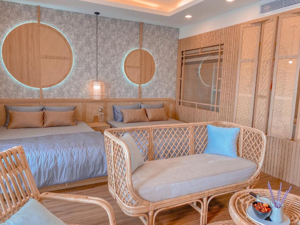 a bedroom with two beds and a chair and a table at Q House- FLC Sea Tower in Quy Nhon