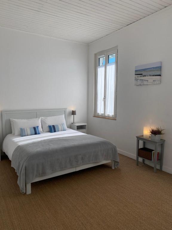 a white bedroom with a large bed and a window at L&#39;Estanquet Bed and Breakfast pdj offert in Gastes