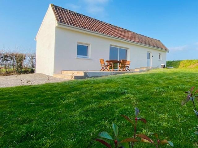 une maison avec une table et des chaises dans une cour dans l'établissement Gîte de la Prévosserie, à Rinxent