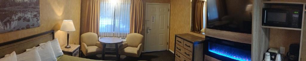 ein Hotelzimmer mit einem Bett und einem TV in der Unterkunft Cedar Lodge in El Portal