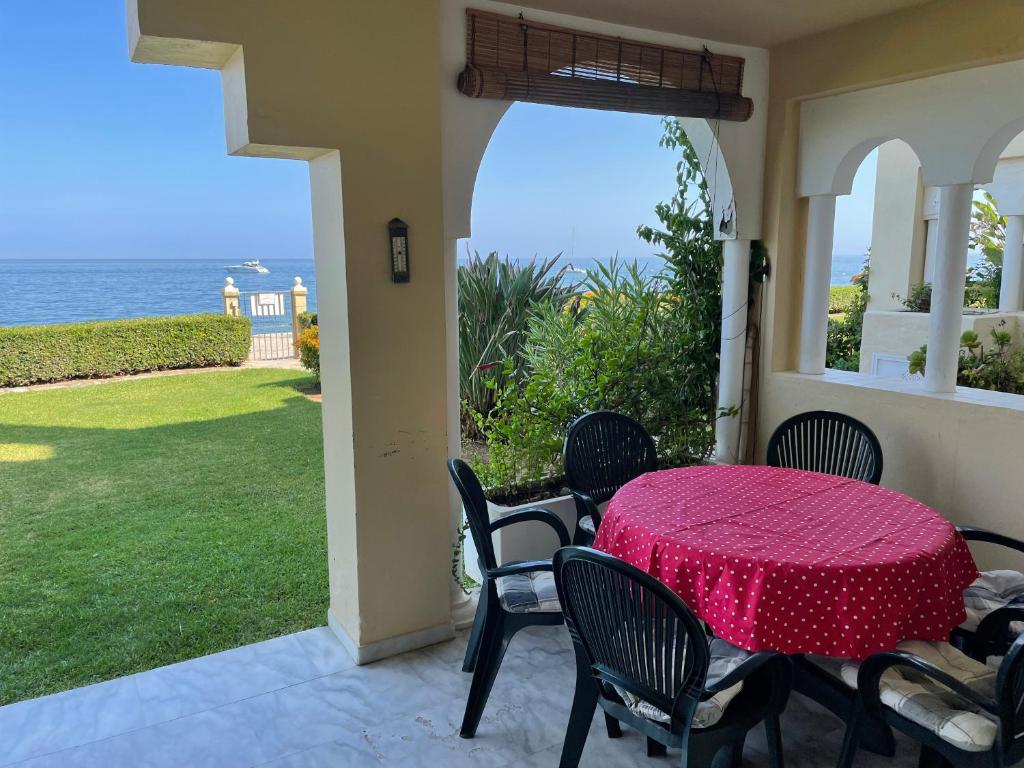 une terrasse avec une table et des chaises et l'océan dans l'établissement El Lobo de Mar Estepona, à Estepona