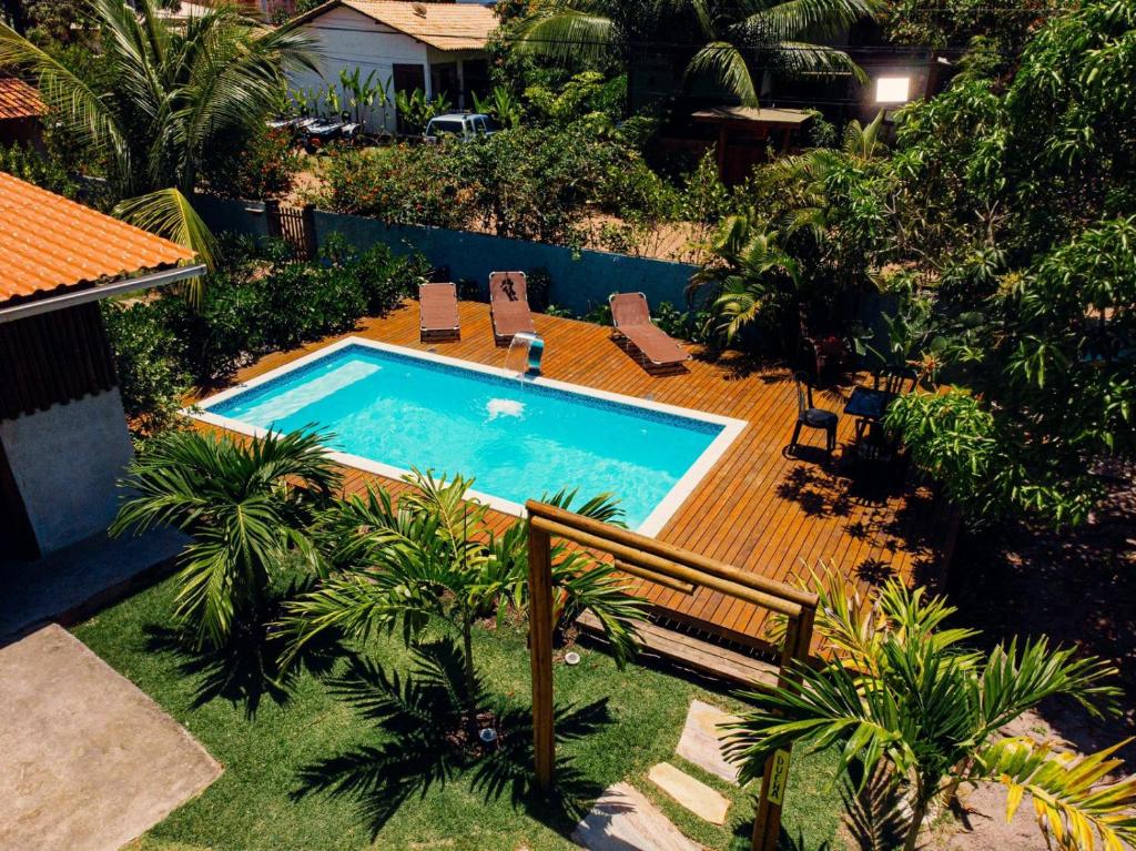 a swimming pool in a yard with palm trees at Morada Toniatti in Barra Grande