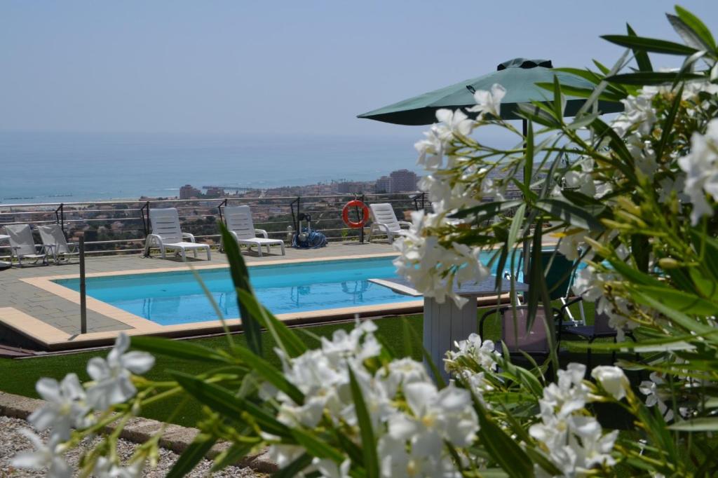 a view of a swimming pool with white flowers at Punto di vista in Roseto degli Abruzzi