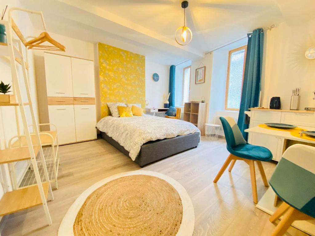 Schlafzimmer mit einem Bett, einem Schreibtisch und einem Tisch in der Unterkunft appartement chic in Laon