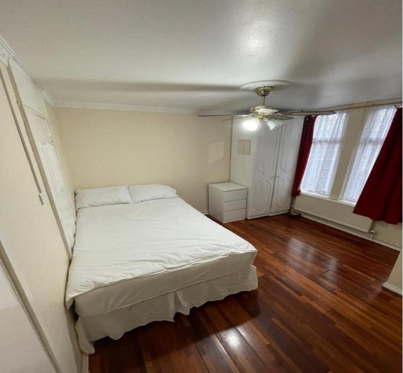 1 dormitorio con cama blanca y suelo de madera en 41 Tanners Endlane, en Edmonton