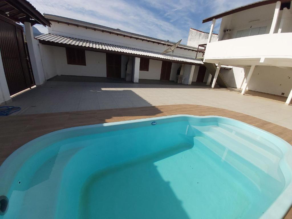 een groot blauw zwembad voor een gebouw bij 0006.02 - Maranduba - Chalé - 1 Dorm - 5 Pess - 3 Quadras Do Mar - Piscina Coletiva - WIFI in Ubatuba