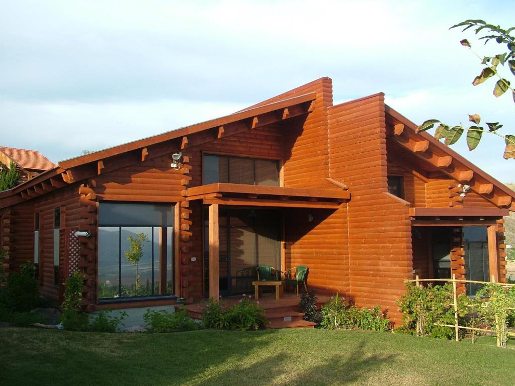 uma casa de madeira com uma grande janela e um relvado em Ein Harod Country Lodge em ‘En H̱arod