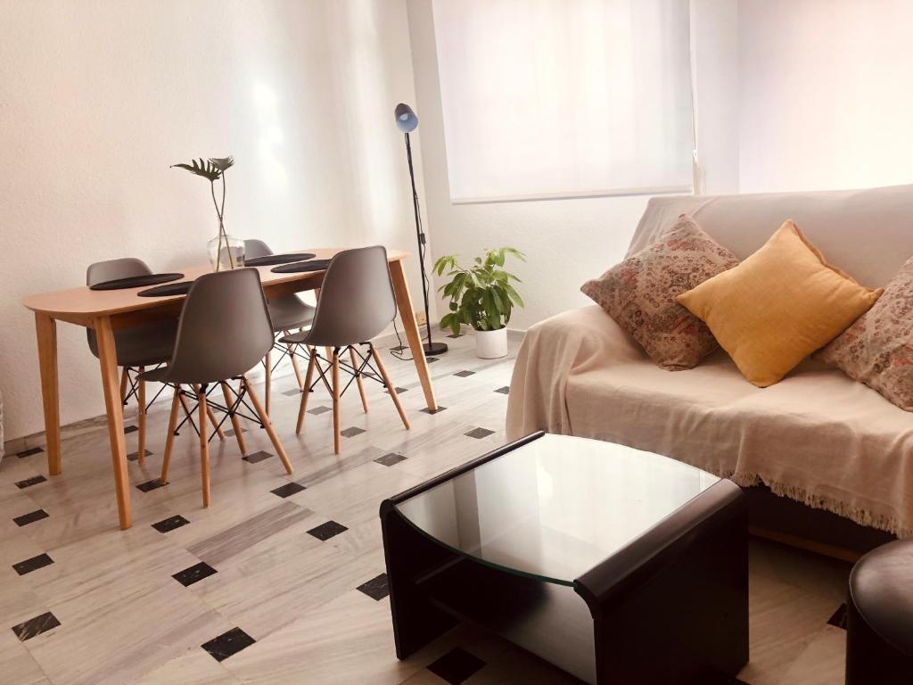 salon ze stołem i kanapą w obiekcie Apartamento Bahía Jardín w mieście La Herradura