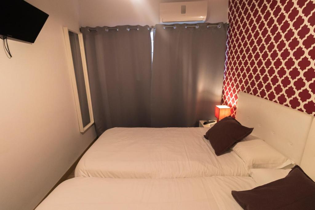 A bed or beds in a room at R&M ALOJAMIENTOS C/SIERPES 46