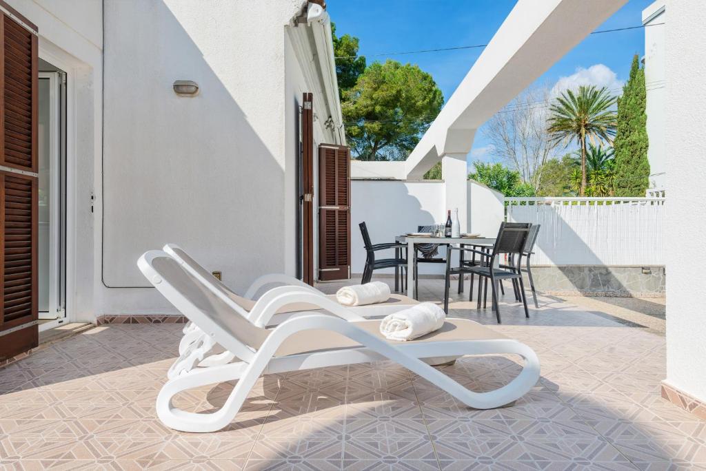 a white rocking chair on the patio of a house at Casa Hawaii in Port d'Alcudia