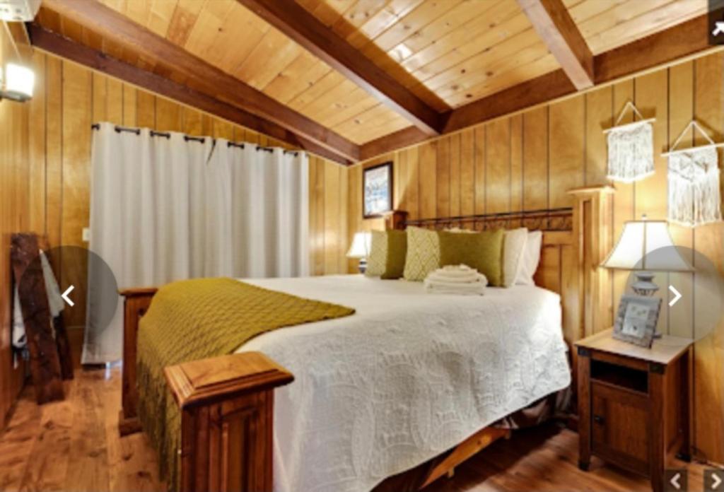 a bedroom with a bed in a room with wooden walls at Apple Belle Cabin Mountain Escape in Oakhurst