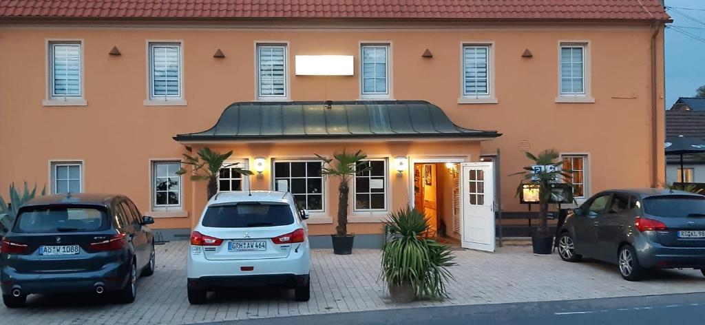 un grupo de coches estacionados frente a un edificio en Hotel und Pension Al Dente, en Nünchritz