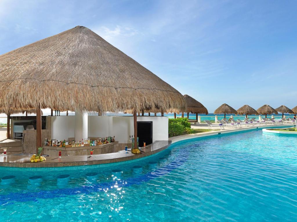 a resort with a swimming pool and a bar at Paradisus Cancun All Inclusive in Cancún