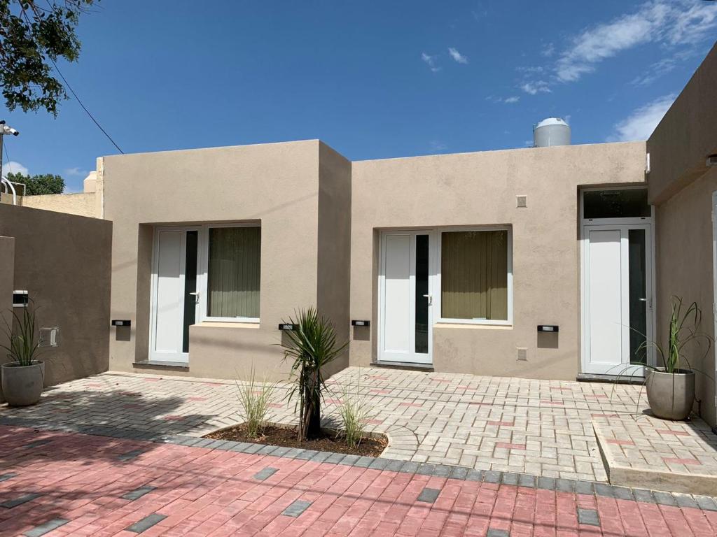 a house with a palm tree in front of it at Costanera Aparts in Villa María