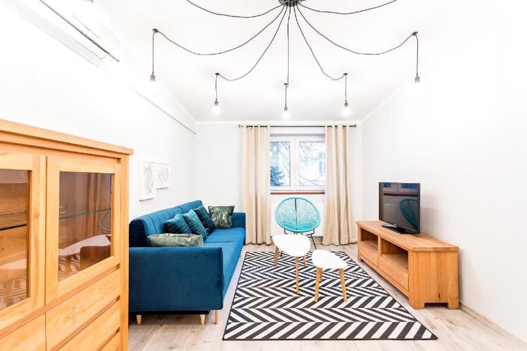 a living room with a blue couch and a tv at Next to the Wawel Castle in Krakow