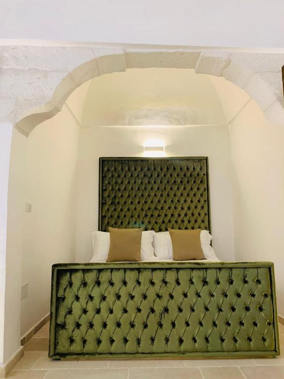 a bedroom with a bed with a green headboard at Maison TN appartamento luxury in Ostuni