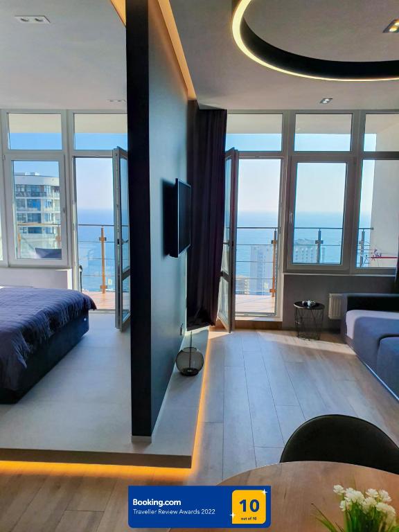 a bedroom with a bed and a view of the ocean at Level 24 - Sea & Sky View Apartment in Odesa