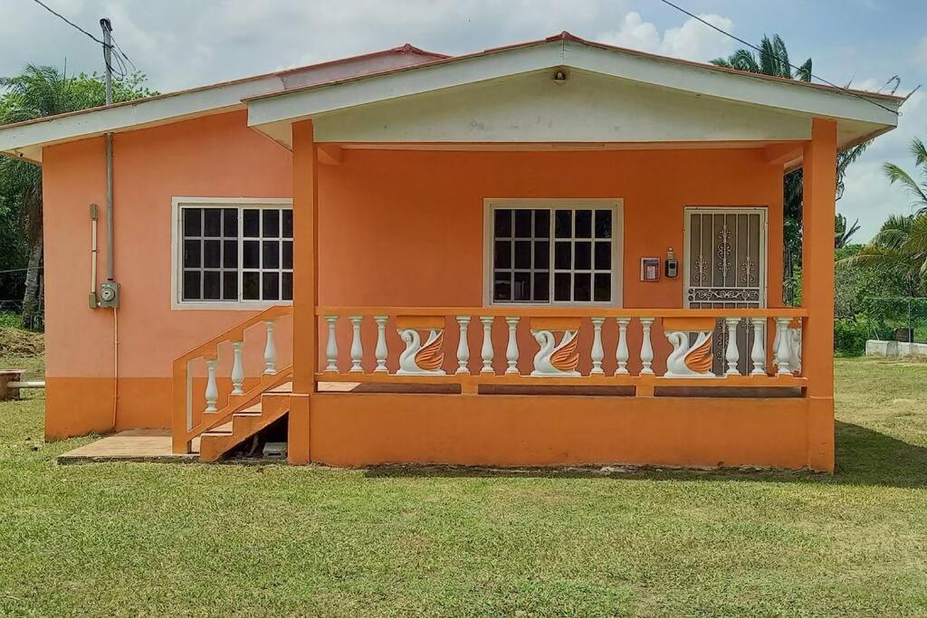 a small orange house with a balcony in the yard at Royal Properties Link in Crooked Tree