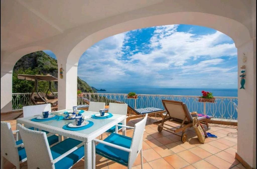 a patio with a table and chairs and the ocean at Villa SEASIDE in Praiano