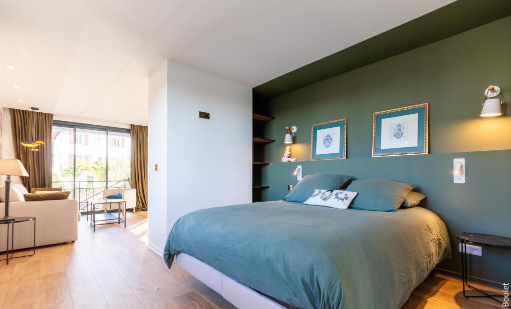 um quarto com uma cama e uma parede verde em VILLA BIBI CHERI Elégante Suite de 35 M2 em Biarritz