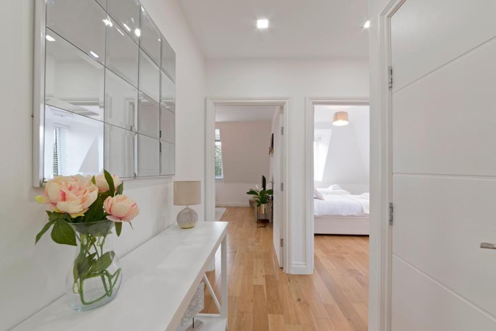 a white room with a vase of flowers on a counter at Spacious Two Bed loft Apartment in Birchanger