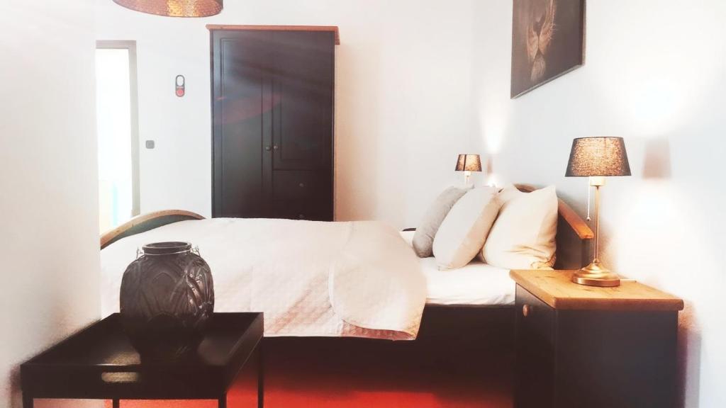 1 dormitorio con 1 cama y 1 mesa con lámpara en Stadthotel, en Rochlitz