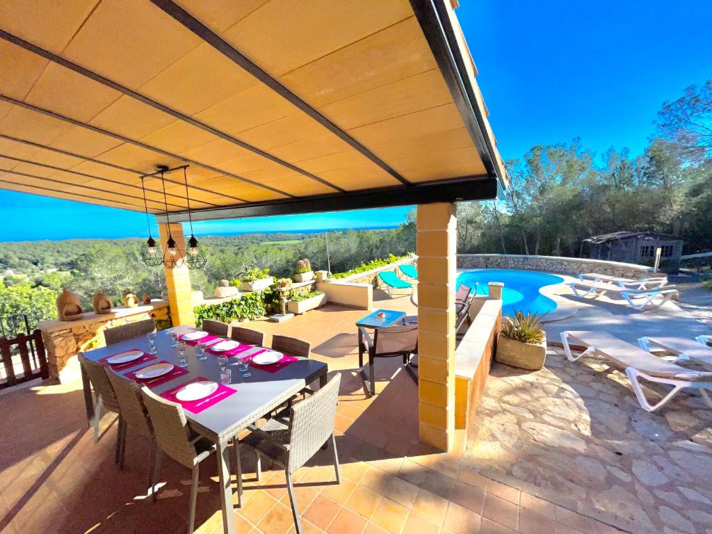 a patio with a table and chairs and a pool at es cau in Manacor