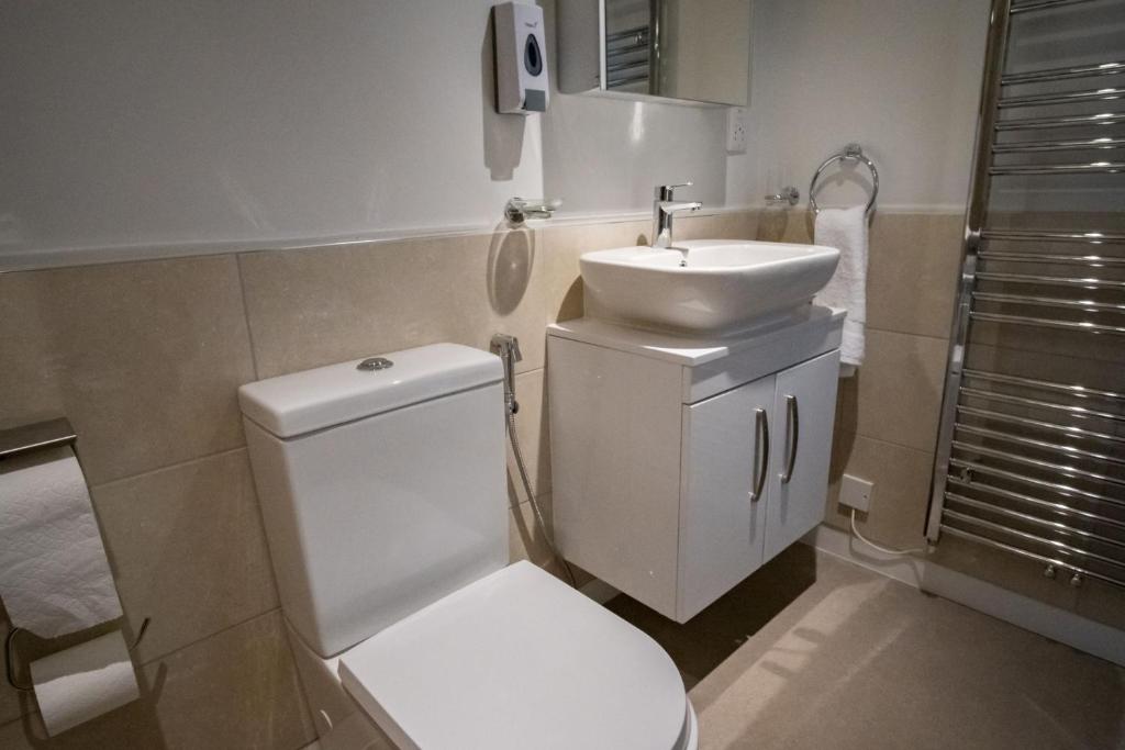 a bathroom with a white toilet and a sink at Magnolia House, Rye in Rye