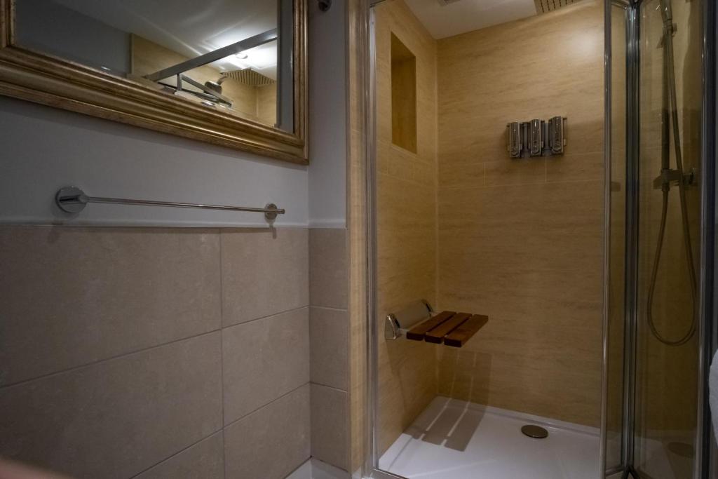 a bathroom with a shower and a mirror at Magnolia House, Rye in Rye