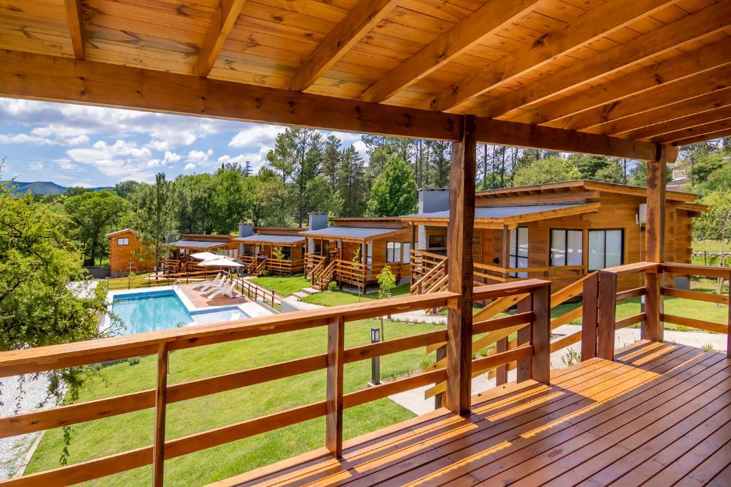 um grande deque com uma casa e uma piscina em Monviso - Casas de montaña em Santa Rosa de Calamuchita