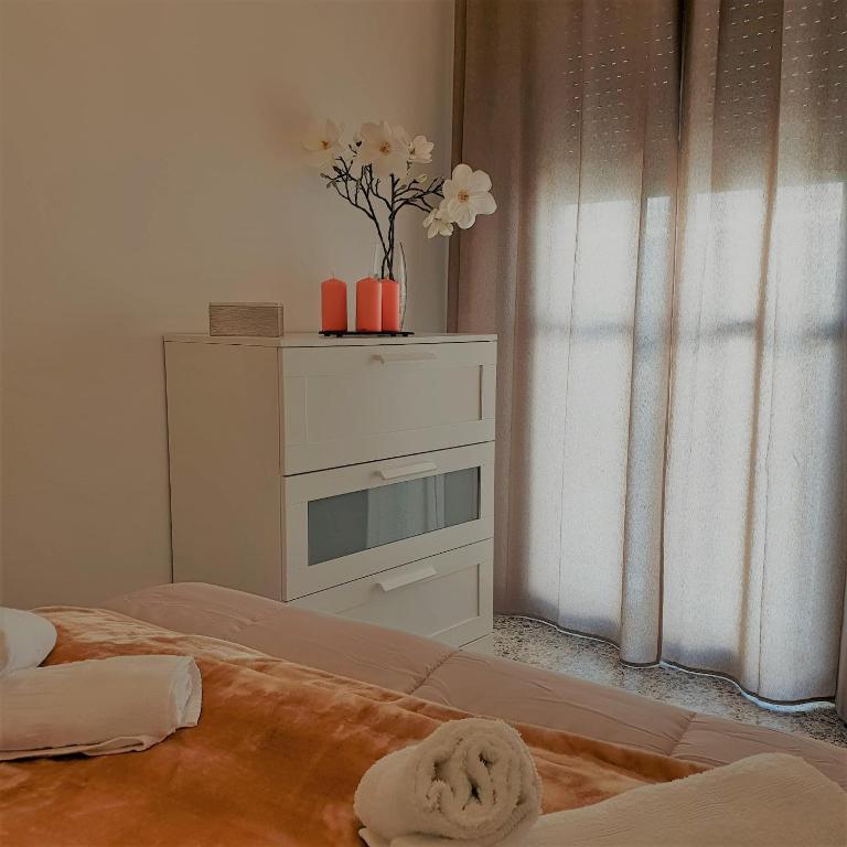 a room with a bed and a dresser with flowers on it at Laverdura in Ubrique