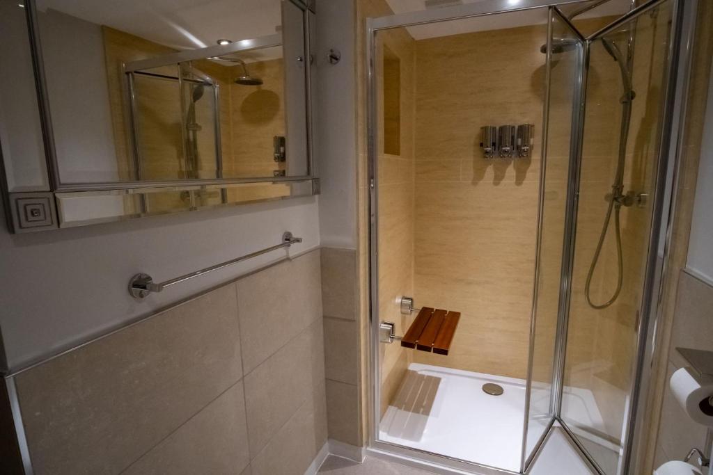 a shower with a glass door in a bathroom at Magnolia House, Rye in Rye
