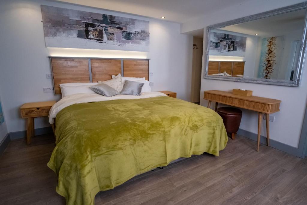a bedroom with a large bed with a green blanket at Magnolia House, Rye in Rye