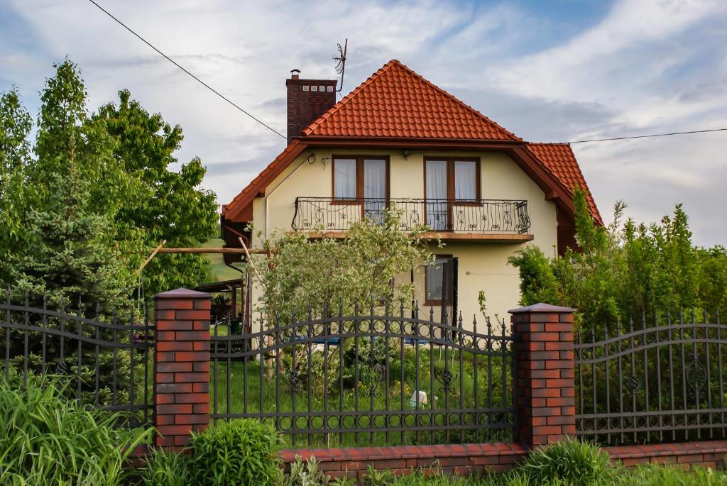 una casa con una puerta de hierro y una valla en Agroturystyka u Aleksa en Krajno-Zagórze