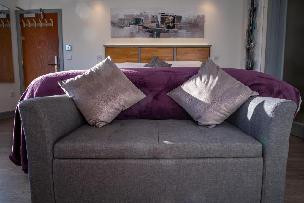 a couch with pillows on it with a bed at Magnolia House, Rye in Rye